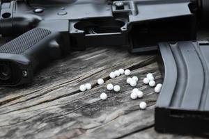 Closeup of white plastic bullets of airsoft gun or bb gun on wooden floor, soft and selective focus on white bullets. photo