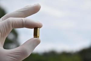 Forensic officers holds physical evidence which is the bullet shell up to eye level to determine the size and type of ammunition at the murder. photo