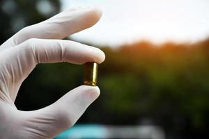 Forensic officers holds physical evidence which is the bullet shell up to eye level to determine the size and type of ammunition at the murder. photo