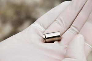 Forensic officers holds physical evidence which is the bullet shell up to eye level to determine the size and type of ammunition at the murder. photo