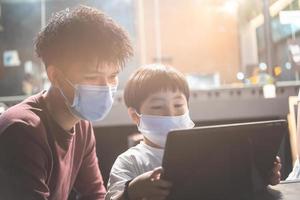 educación asiática hombre niño mirando tableta en la oficina para prepararse para la entrada del examen para aprender la lección de capacitación en línea conocimiento de la tarea digital familia de la escuela foto