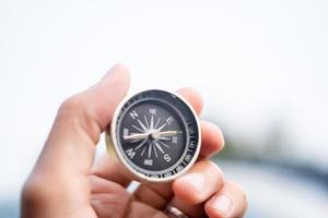 Man hand holding compass on city and car blurred background Using wallpaper or background travel or navigator image. photo