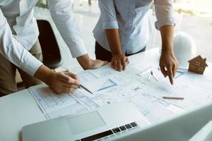 Structural engineering designers are working on the blueprints and analyzing them together. photo