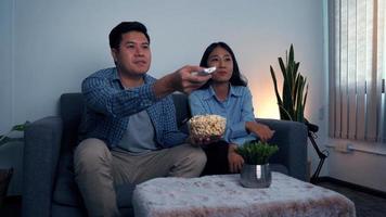 Asian couples watch movies on TV on weekends at night. photo