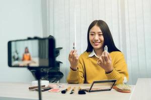 Young Asian beauty blogger is showcasing cosmetic products as well as tutorials on how to apply and record makeup tutorials on social media networks. photo