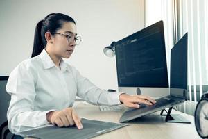 los desarrolladores de software están analizando el código escrito en el programa en la computadora en la sala de oficina.