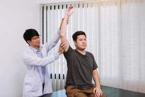 quiropráctico estirando el brazo de un joven en el consultorio médico