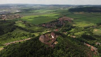 Flygfoto över gamla slottet i grönt fält och by - kretsande video