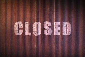 Closed sign on old zinc sheet rust background. photo