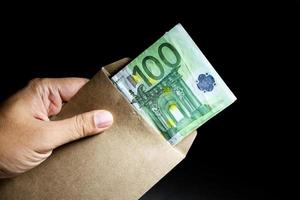 Male hand holding salary envelope euro money banknotes. photo