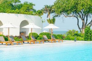 umbrella with bed pool around swimming pool with ocean sea background photo