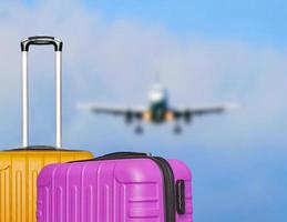 Suitcases and the blure boarding plane in the blue sky. photo