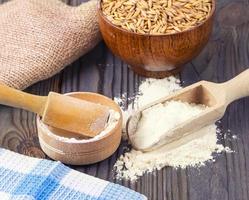 The  flour pile and wheat grains in wooden spoon and bowl photo