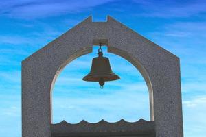 The bell at front with  the blue sky with the clear horizon on the background. photo