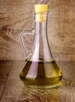 Extra virgin healthy Olive oil on wooden surface photo