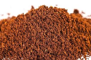 The pile of the ground coffee flakes isolated over the white background. photo
