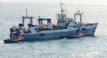 Tug boats and cargo ship entering the harbor on Kamchatka photo