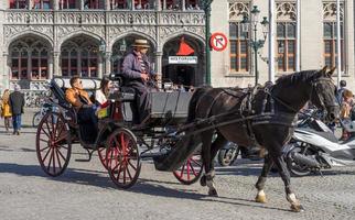 brujas, bélgica, 2015. caballo y carruaje en la plaza del mercado de brujas foto