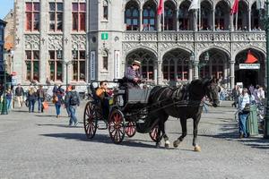 brujas, bélgica, 2015. caballo y carruaje en la plaza del mercado brujas flandes occidental en bélgica foto