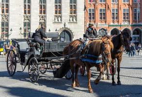 brujas, bélgica, 2015. caballos y carruajes en la plaza del mercado brujas flandes occidental en bélgica foto