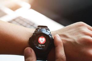 Close up white smart watch with icon Heart rate, healthcare concept. photo