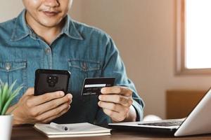 los hombres de negocios usan sus tarjetas de crédito a través de aplicaciones de banca móvil por Internet para comprar en línea e ideas de pago digital. foto
