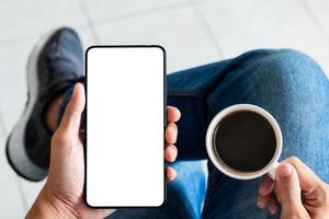 mockup copy space phone, man's hand holding smartphone with blank white copy screen for your advertising and message or information content, mobile on desk at coffee shop. photo