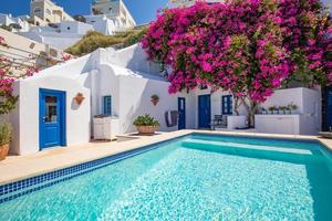 isla de santorini, grecia - 24.05.2022. una vista de la caldera y la piscina del hotel de lujo en primer plano, arquitectura blanca típica del pueblo de imerovigli en la isla de santorini, grecia. foto