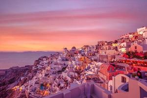 increíble vista nocturna de la isla de santorini. pintoresca puesta de sol de primavera en el famoso pueblo de fira, grecia, europa. fondo del concepto de viaje. paisaje de puesta de sol inspirador artístico, vacaciones de ensueño foto