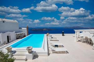 Luxury travel vacation landscape with infinity pool, swimming pool with sea view. White architecture on Santorini island, Greece. Beautiful landscape with sea view
