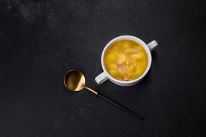 Fresh pea soup in bowl on black background. Cooking at home photo