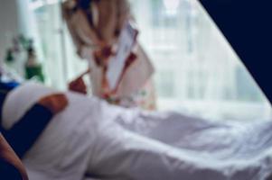 The background image blurred the patient to sleep in the patient bed. While the hand is still working on the business photo