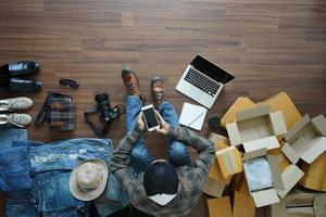 vista superior de los hombres que usan teléfonos inteligentes, vendiendo en línea el concepto de ideas de propietarios de pequeñas empresas foto