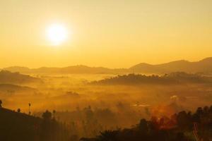 The morning sun and the orange sky are above the mountains. photo