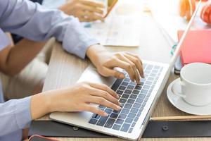 The hands of a woman are using a laptop computer to working at home. Working from home or working at home concepts. photo