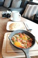 Fried eggs in pan with pork and all vegetable on wood table. It's Vietnamese style and popular in south east asia. photo