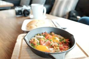 Fried eggs in pan with pork and all vegetable on wood table. It's Vietnamese style and popular in south east asia. photo
