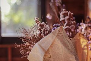 enfoque suave de flores secas en envoltura de periódico para decoración. foto