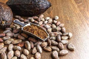 cacao en polvo y cacao en grano sobre mesa de madera foto