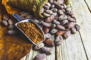 Cocoa powder and cocoa bean on wooden table photo