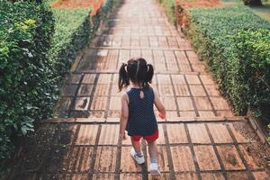 View from the back. girl running down brick stairs In the park in the evening, there is a sunset light. girl growing up success concept. photo