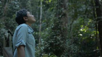 asiatisk kvinna naturforskare söker riktning under att utforska i regnskogen i Thailand. video