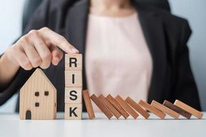 Businessman stop falling wooden blocks and protect house model. Crisis, fall Business, Risk, Economic recession, Developer, Real Estate and Property concept photo