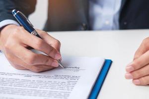 man signing on contract documents after reading, man holding pen and approve on business report. Contract agreement, law and deal concepts photo