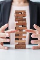 Businesswoman hand cover wooden block on the tower. Business planning, Risk Management, Solution, insurance and strategy Concepts photo