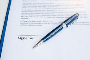 signature with pen on contract documents. Contract agreement, approve, law and deal concepts photo