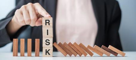 Businesswoman hand Stopping Falling wooden Blocks or Dominoes. Business, Risk Management, Solution, Insurance and strategy Concepts photo