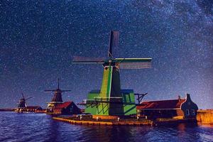 Starry sky over Dutch windmills from the canal in Rotterdam photo