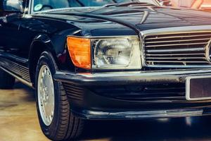 closeup of the headlights and front bumper on vintage automobile photo