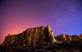 el cielo estrellado sobre las montañas rocosas. foto